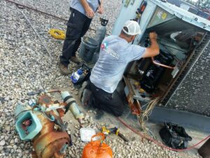 Two technicians from Madison HVAC/R, Inc repairing a commercial rooftop HVAC unit in Richmond, KY.