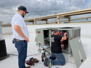 Community Mechanical technicians servicing a commercial rooftop HVAC unit in Plano, TX.