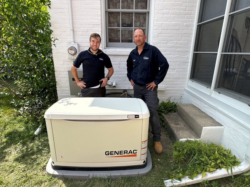 Two technicians standing next to a Generac whole-house generator, installed by All Comfort Services in Madison, WI