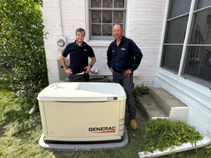 Two technicians standing next to a Generac whole-house generator, installed by All Comfort Services in Madison, WI