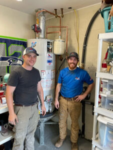 Two technicians standing proudly next to a newly installed water heater by Pipe Wrench Plumbing, Heating & Cooling, Inc in Knoxville, TN.