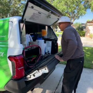 A Terminix technician preparing equipment from the back of a branded service truck in Springfield, IL.