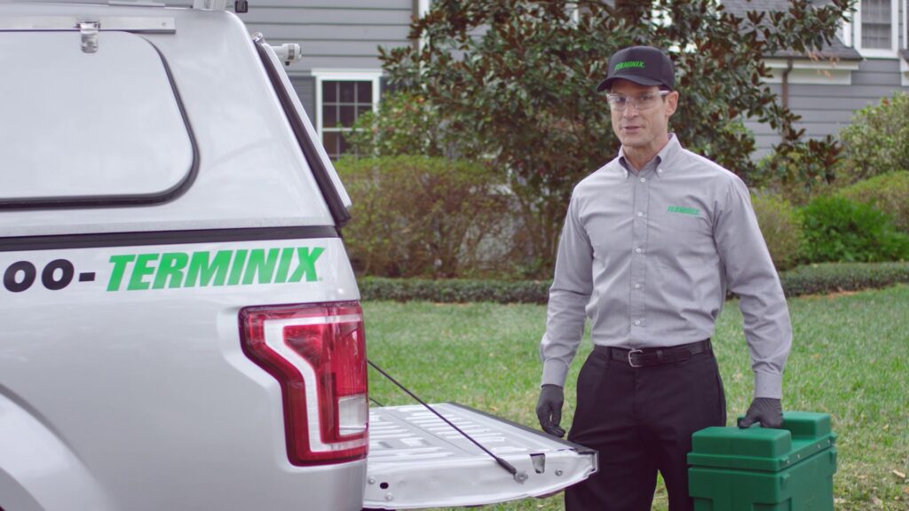 A Terminix technician standing by a branded truck with pest control equipment in Springfield, IL.