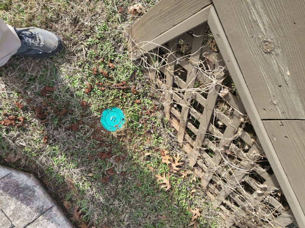 A termite bait station installed in the ground by A Plus Pest Control in Huntsville, AL.