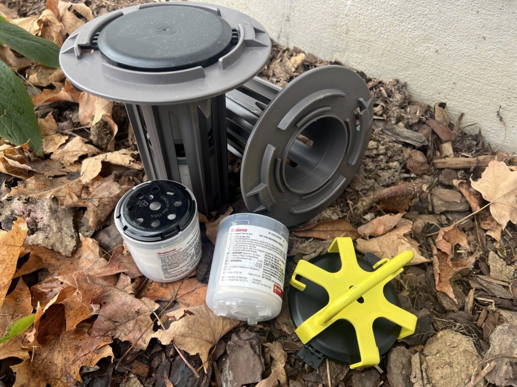 Termite bait stations and bait cartridges laid out on the ground for termite control by EcoPro Termite & Pest in Dayton, OH