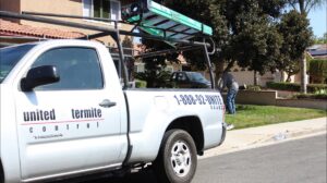 A United Termite Control truck with equipment parked at a residential job site in San Marcos, CA, ready for pest control work.