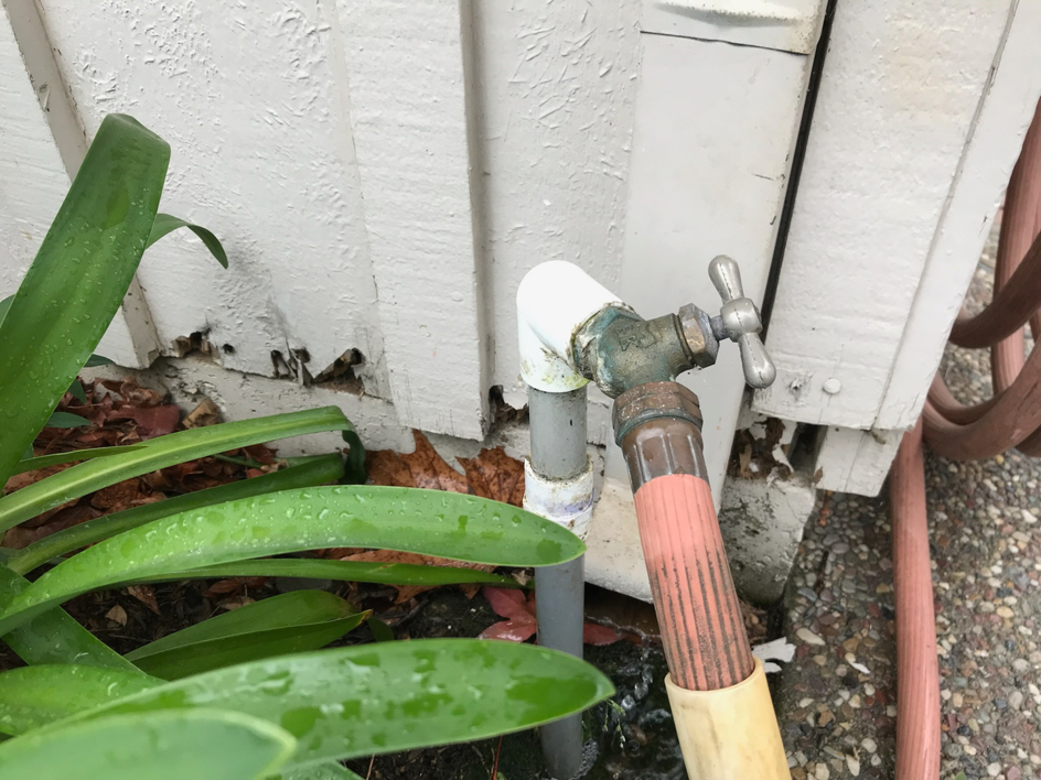 Close-up of termite damage on a house foundation near a water spigot, indicating pest control needs by Innova Termite in San Jose, CA.