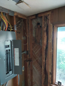 An exposed wall showing wood damage, likely from termites, during an inspection by The Bug Guy in Springfield, MO.