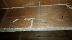 Extensive termite mud tubes on a wooden structure, showing a serious infestation addressed by Berry & Yates Pest Control in Chicago, IL.