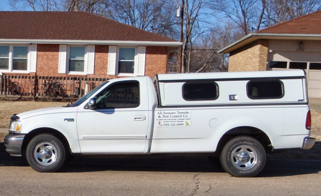 A white service truck for All Seasons Termite & Pest Control Co. parked in Topeka, KS.