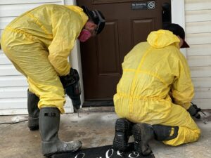 Absolute Pest Solutions technicians drilling into a foundation for termite treatment or pest barrier in Piedmont, OK.