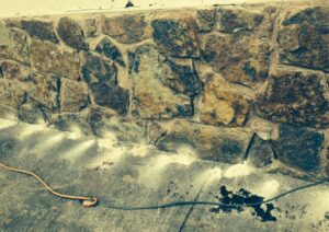 Termite treatment being applied to a stone foundation by Roach's Termite Service Inc. in Oklahoma City, OK