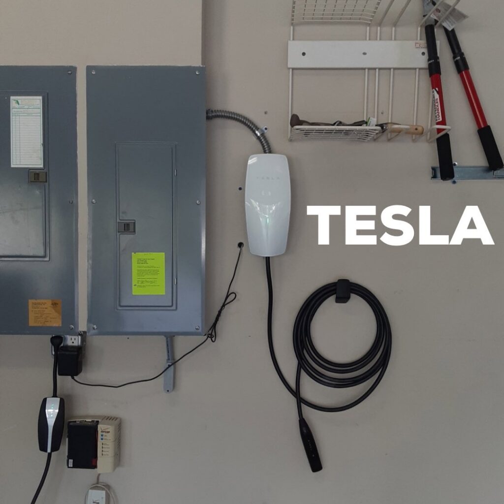 A Tesla EV charger and electrical panels professionally installed in a garage by Fuller Electrical Contractors, Inc. in Oldsmar, FL.