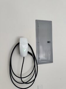A Tesla electric vehicle charger installed next to an electrical subpanel by Castle Electrical & Lighting in Scottsdale, AZ.