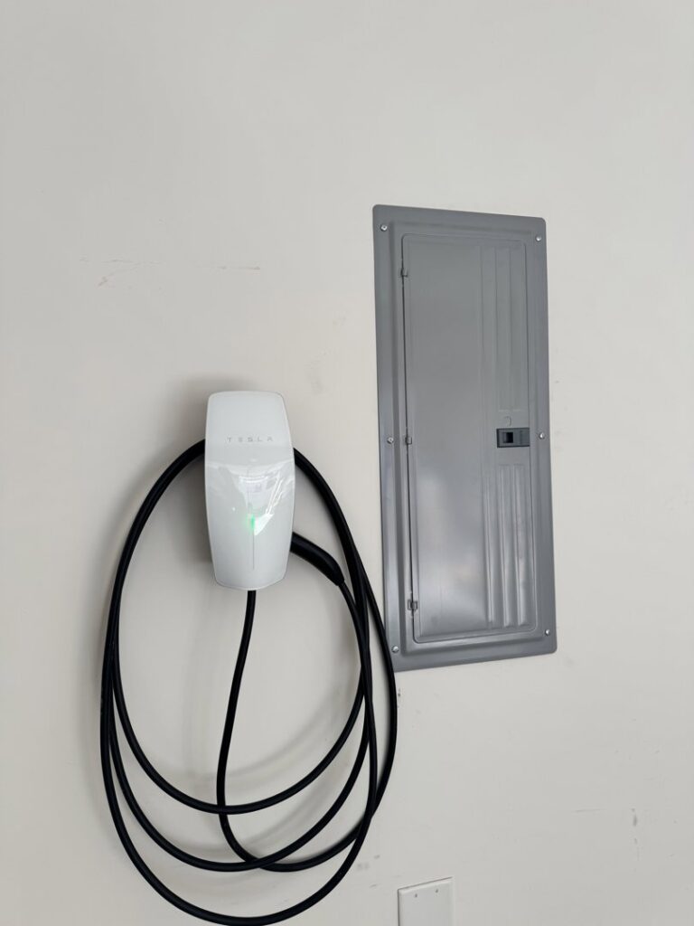 A Tesla electric vehicle charger installed next to an electrical subpanel by Castle Electrical & Lighting in Scottsdale, AZ.