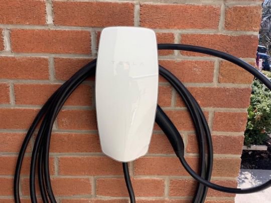 An exterior Tesla EV charger installation on a brick wall by Decatur Electrician Now in Decatur, AL.