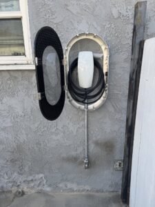 A newly installed Tesla EV charger on an exterior wall, completed by CLB Electric Corporation in Norwalk, CA