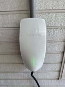 A Tesla EV charger installed on an exterior wall by Steadfast Electric, LLC in Baton Rouge, LA.