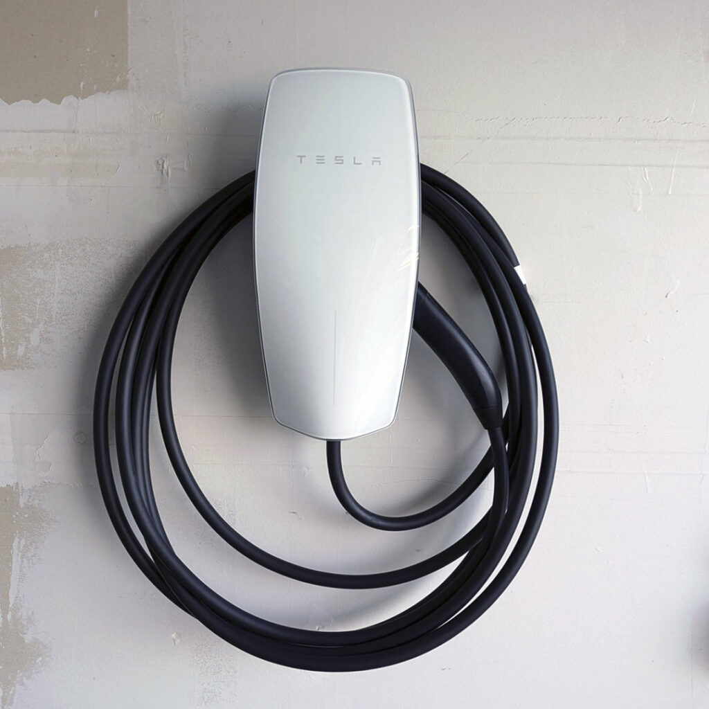A Tesla electric vehicle charger professionally installed on a wall by Fuse Service HVAC & Electrical Sacramento, CA