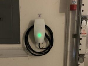 A Tesla EV charger installed in a garage, a service provided by Decatur Electrician Now in Decatur, AL.