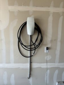 A Tesla EV charger professionally installed on a garage wall by ChargerPro in Denver, CO.