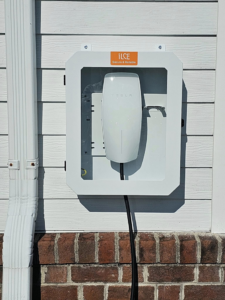 A Tesla EV charger professionally installed on the side of a house by KC Electric in Pompton Plains, NJ.