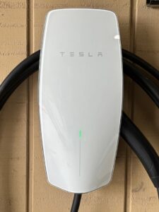 A Tesla EV charger installed on a home's exterior wall by LiveWire Electrical Services, LLC. in Houma, LA.