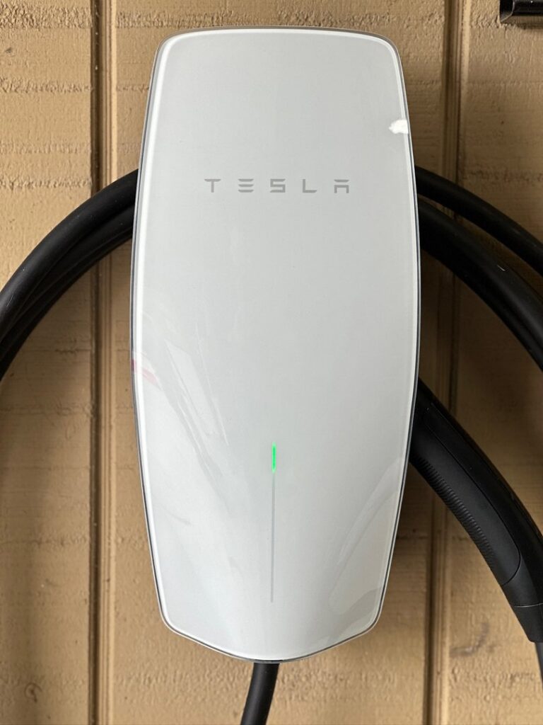 A Tesla EV charger installed on a home's exterior wall by LiveWire Electrical Services, LLC. in Houma, LA.