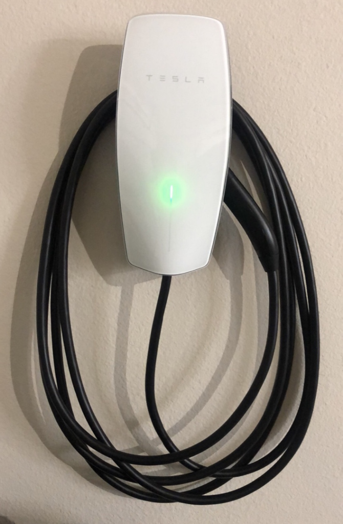 A Tesla EV wall connector charger installed on a wall, a service provided by Penrose Electric in Knoxville, TN