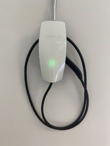 A Tesla EV charger professionally installed on a wall by Power Tech Electrical Services in Durham, NC.