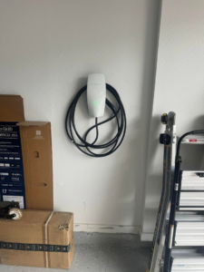 A Tesla electric vehicle charger professionally installed on a garage wall by R&M Electric LLC in Gilbert, AZ.