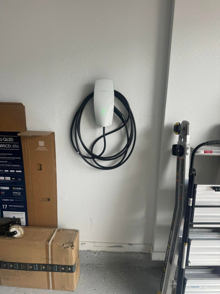 A Tesla electric vehicle charger professionally installed on a garage wall by R&M Electric LLC in Gilbert, AZ.