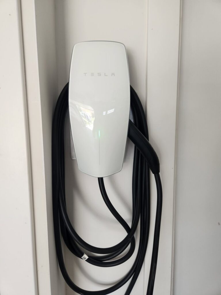 A newly installed Tesla electric vehicle charger on a wall by Robert's Electric Inc. in Manhattan, KS