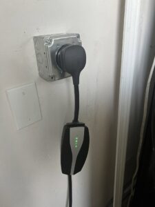 A Tesla electric vehicle charger professionally installed on a wall by Steve Cavenee Electric in Orange, CA.