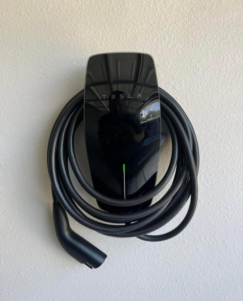 A Tesla EV charger professionally installed on a wall by Vitality Electric in Sacramento, CA.