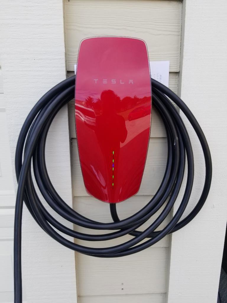 A red Tesla electric vehicle charger professionally installed on a home exterior by Wisdom Electrical in San Francisco, CA.
