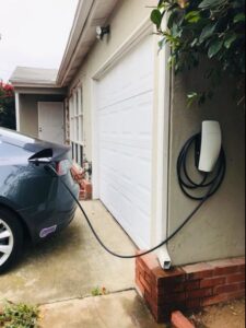 A Tesla electric vehicle charging at a newly installed home charging station by Smith Electrical Contractors, Inc. in El Cajon, CA.