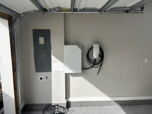 A Tesla Powerwall and EV charger installed next to an electrical panel by Prime Time Electric in Rock Hill, SC.