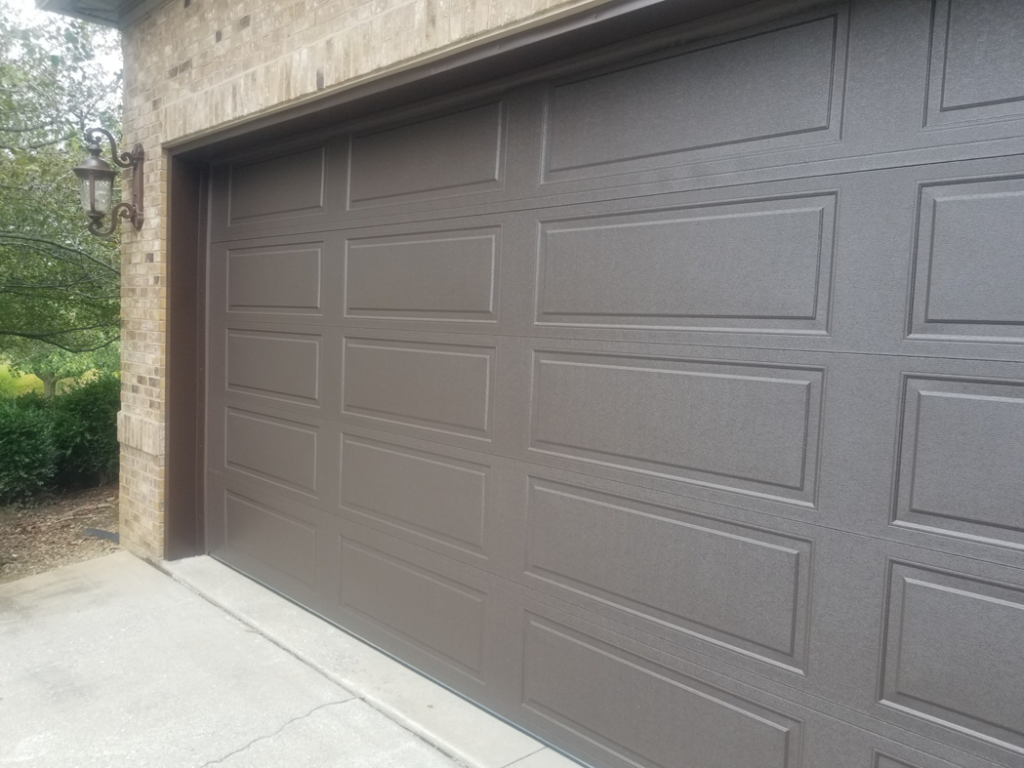 A close-up view of a textured brown garage door installed by Door-Tech LLC in Lexington, KY.