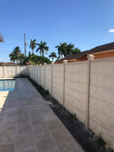 A textured concrete fence installed along a pool patio by Miami Concrete Fence in Miami, FL
