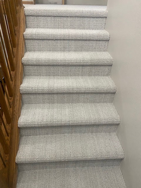 Newly installed textured light gray carpet on a staircase by Fairbanks Carpets Plus in Fairbanks, AK