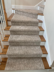 Close-up of a textured grey carpet stair runner installed by The Carpet Workroom in Needham Heights, MA.