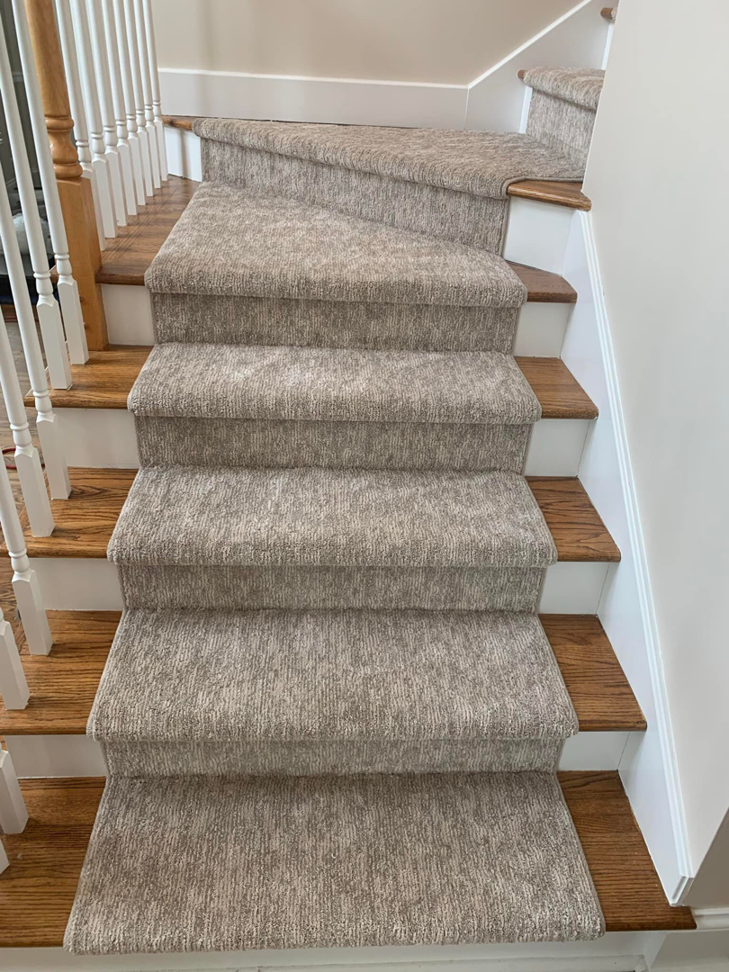Close-up of a textured grey carpet stair runner installed by The Carpet Workroom in Needham Heights, MA.