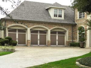 Three arched garage doors installed on a beautiful brick home by Overhead Door Company of Salem in Salem, OR.