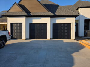 Three modern black garage doors installed on a new construction home by Legacy Garage Doors & Repairs in Church Point, LA.