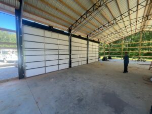 Three large white commercial garage doors installed in a new building by Signature Garage Doors in Huntsville, AL.