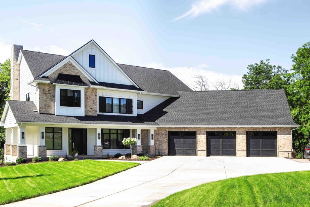 Three dark modern garage doors installed on a large residential home by Overhead Door Company of Salem in Salem, OR.