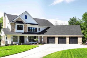 Three dark modern garage doors installed on a large residential home by Overhead Door Company of Salem in Salem, OR.