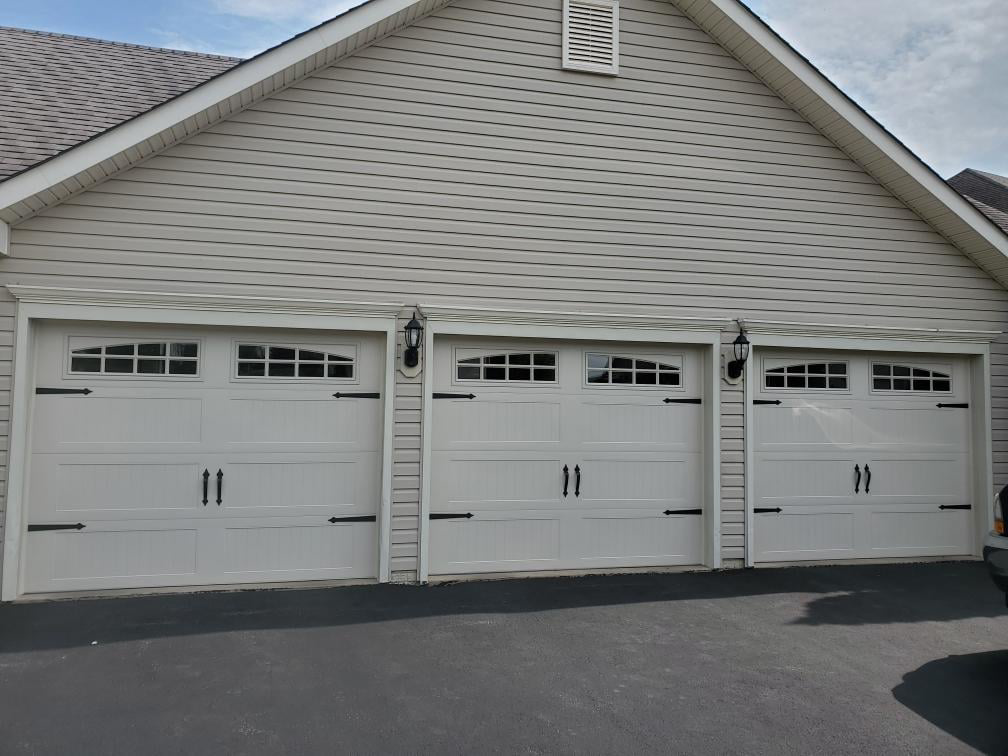 Three decorative white residential garage doors with windows and hardware, installed by Midland Glass and Garage Doors in Frederick, MD
