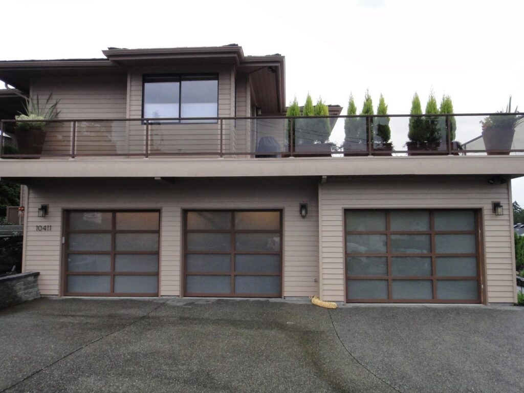 Three modern garage doors with frosted glass panels, expertly installed by Rainier Garage Door in Bellevue, WA.